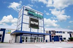 an empty parking lot in front of a building with a sign that says nfm