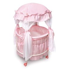 a pink and white baby crib with a canopy