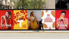 two people walking past a large advertisement on the side of a building