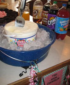 a blue bowl filled with white frosting on top of a counter next to bottles of soda