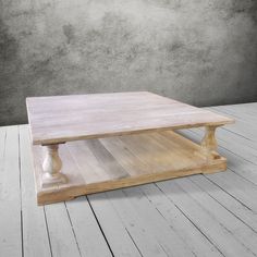 a wooden coffee table sitting on top of a hard wood floor next to a wall