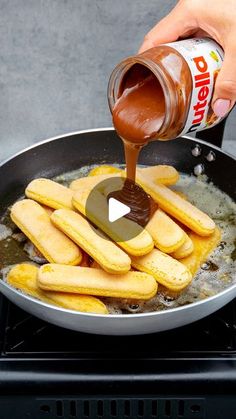 someone is pouring sauce on some food in a frying pan and it's being cooked