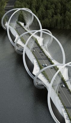 an aerial view of a bridge with cars driving on it and trees in the background