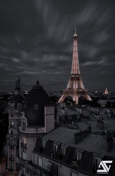 the eiffel tower lit up at night in black and white with dark clouds