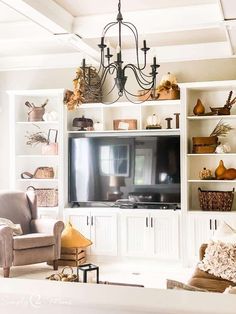 a living room filled with furniture and a flat screen tv on top of a book shelf