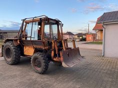 an old tractor parked in front of a house