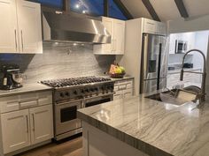 a kitchen with marble counter tops and stainless steel appliances