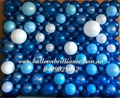 blue and white balloons are arranged in the shape of a rectangle on a wooden surface