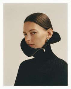 a woman in black turtle neck sweater and earrings