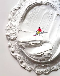 a person riding skis on top of a snow covered slope in a white frame