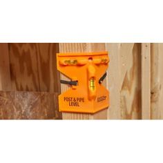 an orange post stapler is attached to a wooden fence