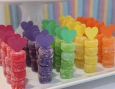 many gummy bears are lined up on a white tray with hearts in the middle