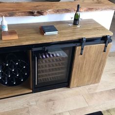 a wine rack with bottles and glasses on it in front of a counter that is made out of wood