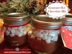 two jars filled with marshmallows sitting on top of a table next to a christmas tree