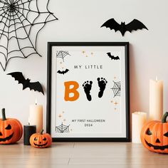 a framed halloween poster on a table with candles and pumpkins