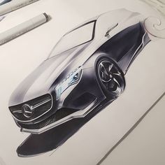 a drawing of a mercedes concept car on a white surface with markers and pencils next to it