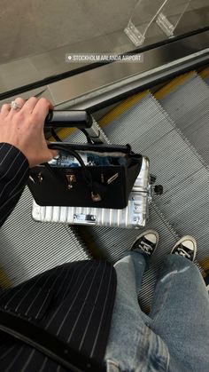 a man is sitting on an escalator with his luggage