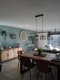 a dining room table with chairs and a clock on the wall