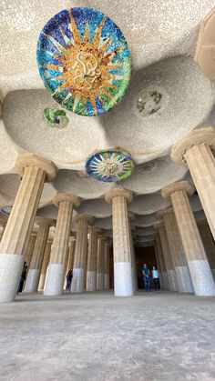 the inside of a building with many pillars and colorful decorations on it's ceiling