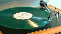 an old record player with its turntable in the foreground and purple tinted background