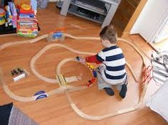 a young boy playing with his toy train set