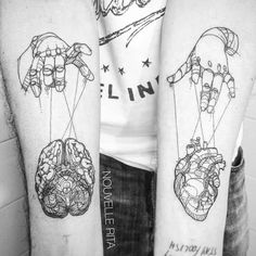 two people with tattoos on their arms are holding hands and heart shaped balloons in the air