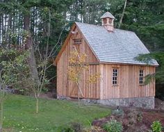 a small wooden building sitting in the middle of a forest with lots of trees around it