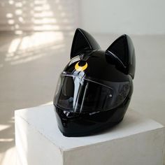 a helmet with a cat's face on it sitting on top of a block