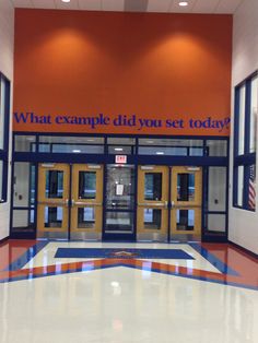 an orange and blue building with two doors that say what example did you set today?