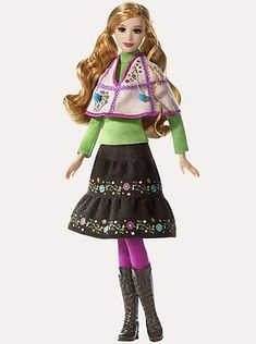 a barbie doll wearing a green sweater and black skirt with flowers on it's chest