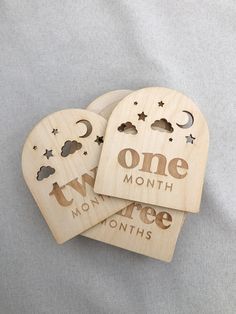 three wooden heart shaped magnets with the words one month and two months printed on them