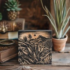 a wooden box sitting on top of a table next to a potted plant