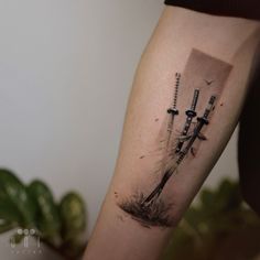 a person with a tattoo on their arm has a knife and two swords in the background