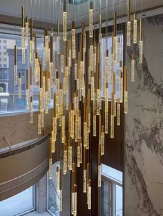 a large chandelier hanging from the ceiling in a lobby with marble walls and flooring