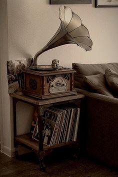 an old fashioned record player sitting on top of a table next to a couch in a living room