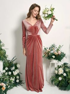 a woman in a long dress holding flowers