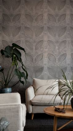 a living room with two couches and some plants on the table in front of it