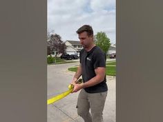 a man holding a yellow hose in his hand