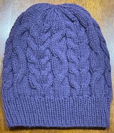 This beanie is knitted in a fun lightweight Cable Knit slouchy style that will help you stay warm during the chilly seasons while still looking stylish.  The great purple  color will go with any outfit in your wardrobe and fun for fall.  Each  beanie is knitted with love and the hope that you or whomever you gift it to will love it for years to come.  Already soft, and will only get softer the longer you love it Easy care,  wash on gentle and dry on low heat or allow to air dry.  Part of the pro Cable Knit Beanie One Size Fits Most, One-size Cable Knit Beanie, Hand Knitted Purple Hat One Size, One Size Cable Knit Beanie, Hand Knitted One Size Purple Hats, Hand Knitted Purple Hat, Hand-knitted One Size Purple Hat, Casual Purple Knitted Beanie, Winter Purple Knitted Hat