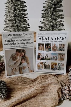 two christmas cards sitting on top of a table next to pine cones and fir trees