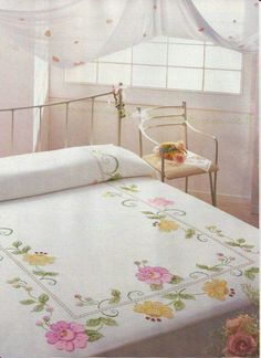 an image of a bedroom setting with flowers on the bedspread and curtains over the bed