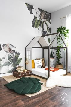 a bedroom with a white bed, green rug and flower wallpaper on the walls