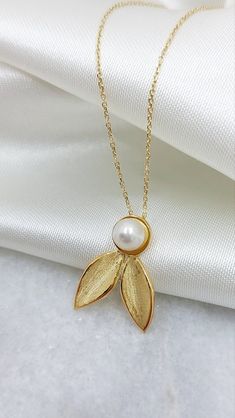 14k Gold Solid Olive leaf Neckalce with Natural Pearl. A jewel that perfectly combines the favorite tree of the Greeks, the olive tree, and the exquisite pearl. The Olive, the most important tree for the Greeks, as a symbol of peace,euphoria, fertility, wisdom and victory and the Pearl as a symbol of purity, integrity and faith. They match perfectly and give us this unique handmade 14k yellow gold set A Minimal necklace  but also unique A perfect gift for yourself or your loved one! Details: Stone: Natural Pearl Pendant length: 2.0 cm Necklace Lenght: 47cm Metal: 14k Yellow Gold ❣️ For more  handmade necklace take a look here      👉  https://www.etsy.com/shop/GiorgosJewelry?ref=seller-platform-mcnav&section_id=21897557 🎁 All of our jewelry come in specially hand packaged gift boxes Olive Jewelry, Symbol Of Peace, Minimal Necklace, Olive Trees, Custom Pendants, Olive Leaf, Yellow Gold Setting, Natural Pearl, Olive Tree