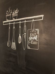 a chalk board with utensils hanging from it