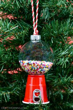 an ornament hanging from a christmas tree filled with candy and sprinkles