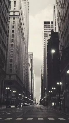 an empty city street with tall buildings on both sides