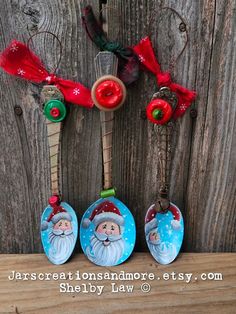 three christmas ornaments hanging on a wooden wall