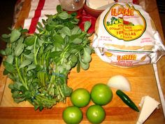 green vegetables are on a cutting board next to garlic and other ingredients for the dish