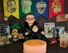 a young boy sitting in front of a harry potter cake