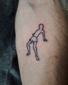 a man's arm with a small tattoo of a person holding a frisbee